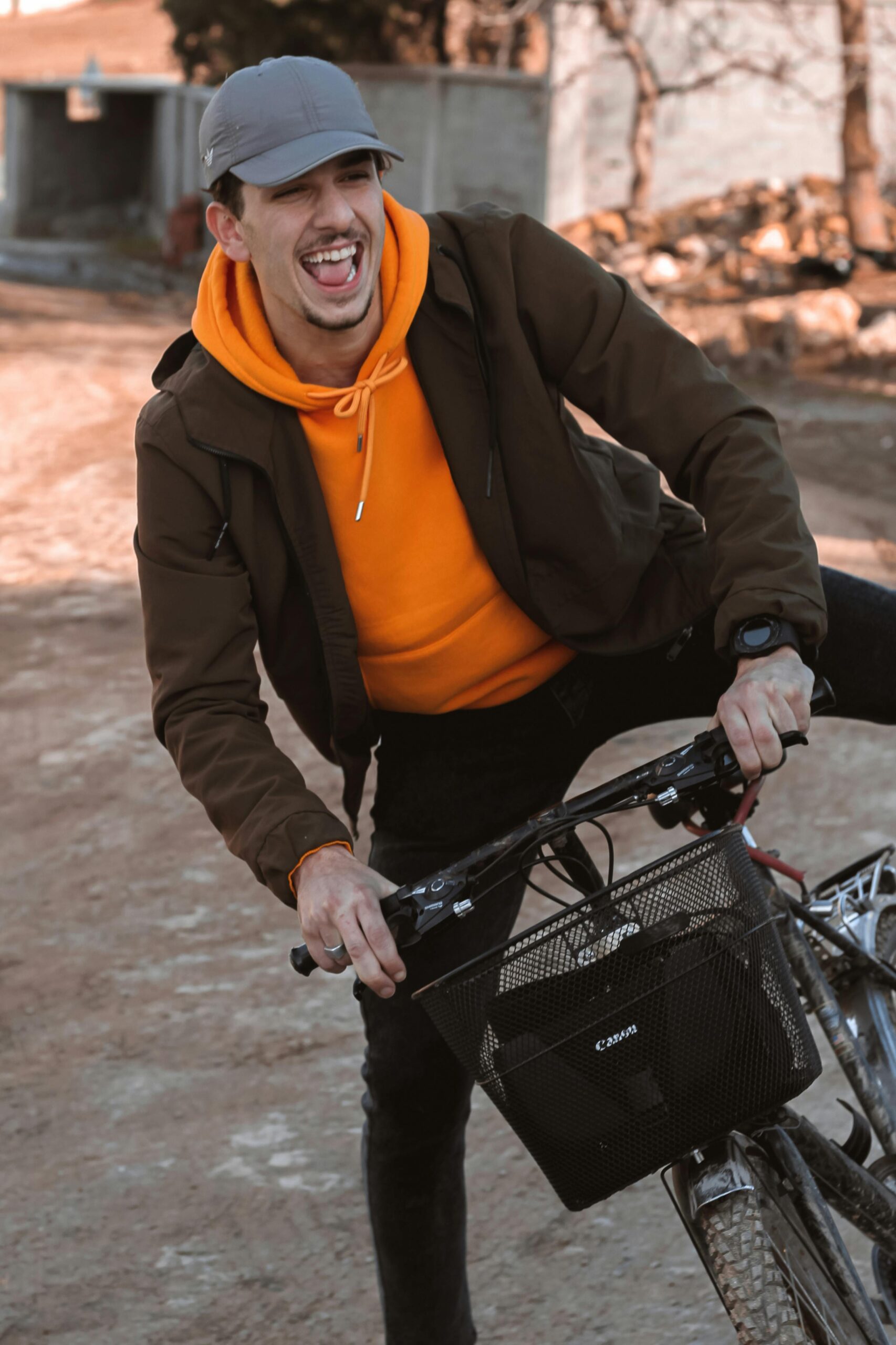 A man enjoying a bike ride outdoors on an autumn day, smiling widely.