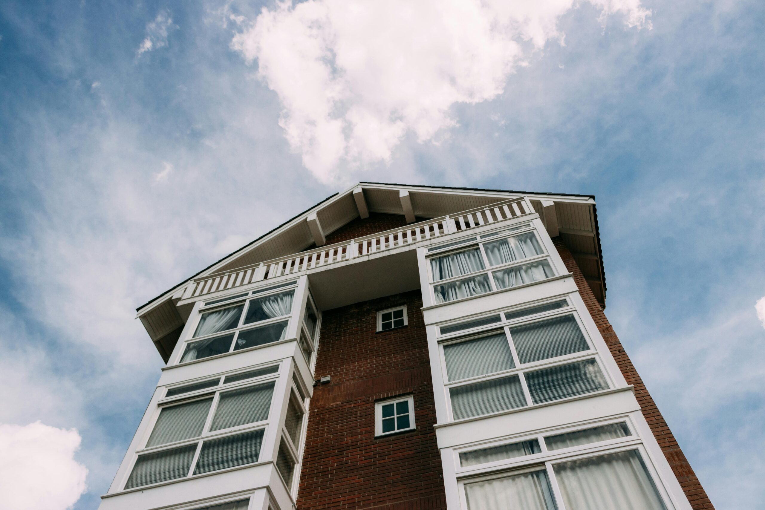 A low-angle view of a modern building exterior in Gramado, Brazil, against a bright blue sky.