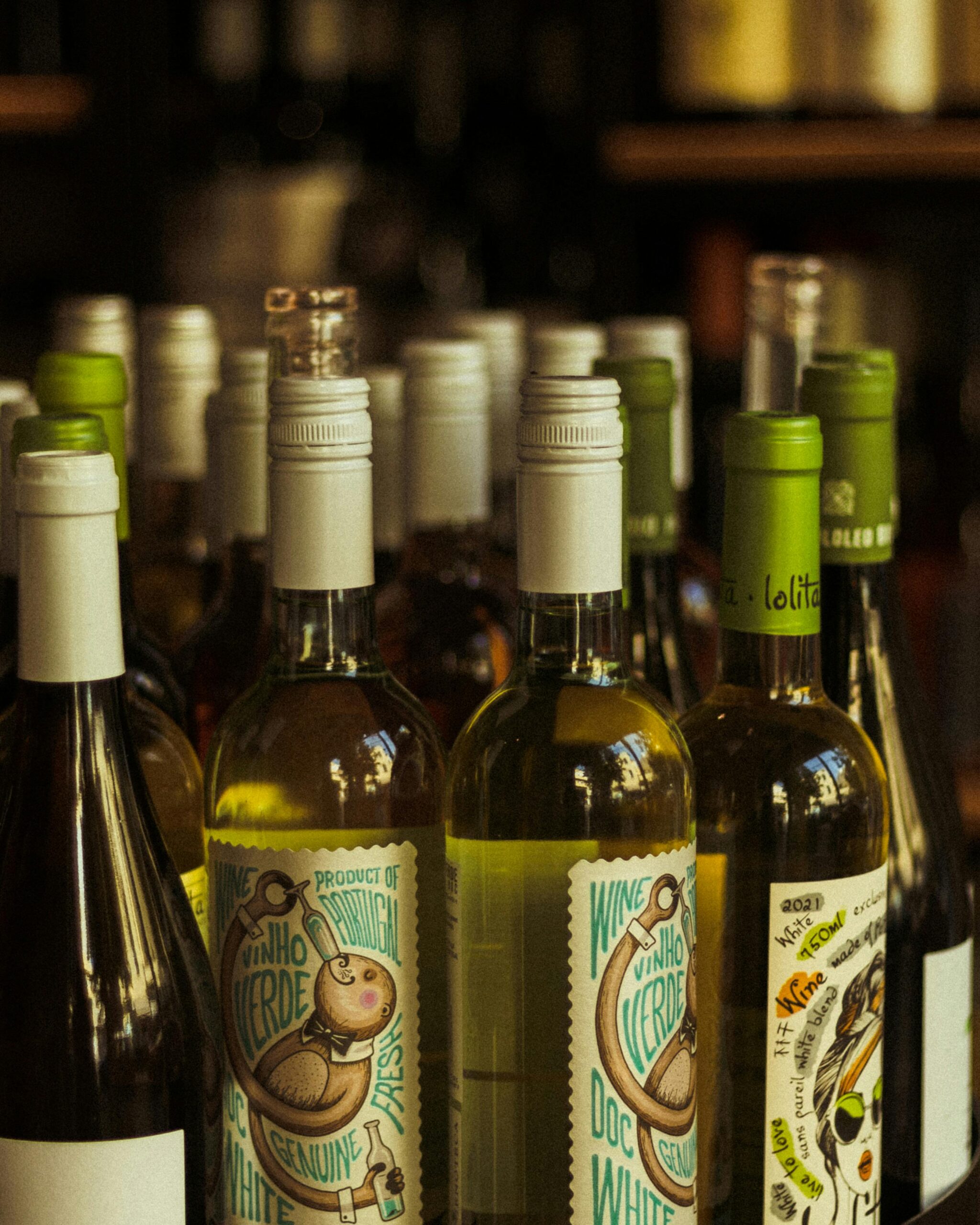 A collection of white wine bottles displayed on a bar shelf, perfect for wine lovers.