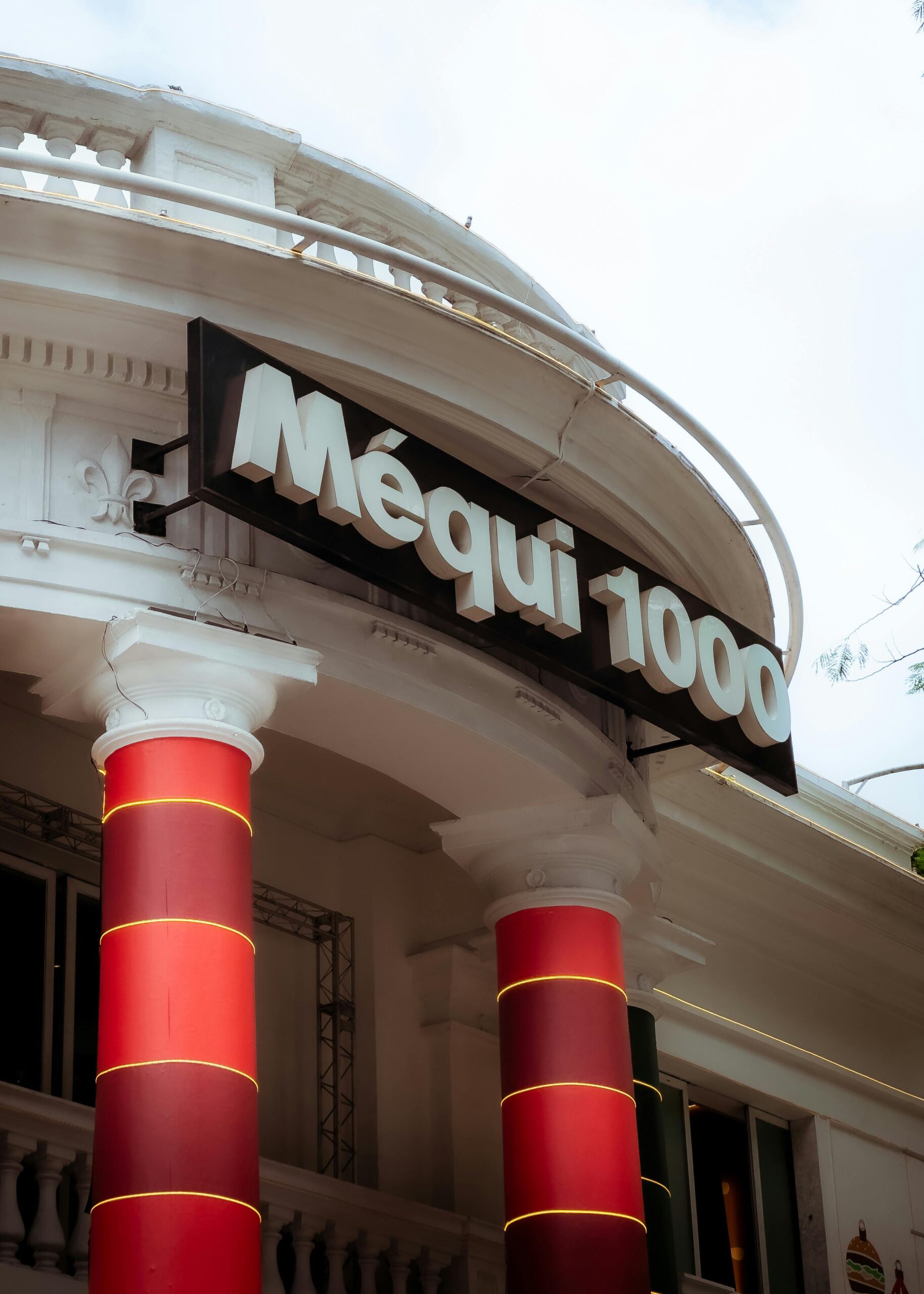 Close-up of Méqui 1000 facade with red columns in São Paulo, Brazil.